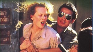 Intense scene from Bangkok Hilton with a woman in distress and a man in sunglasses.